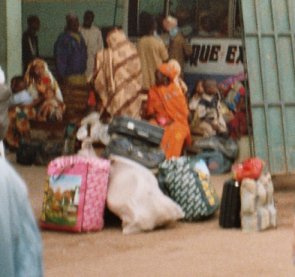 Wartende Buspassagiere mit ihrem Gepäck